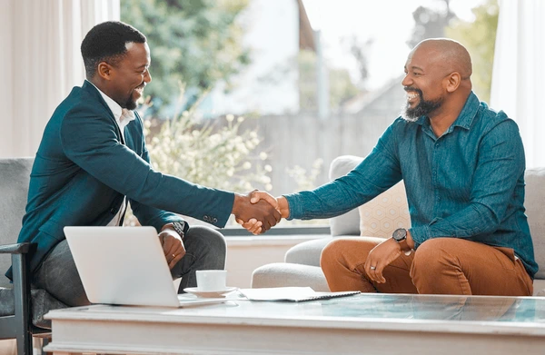 A person shaking hands with a professional in a modern office, symbolizing trust and advisory services